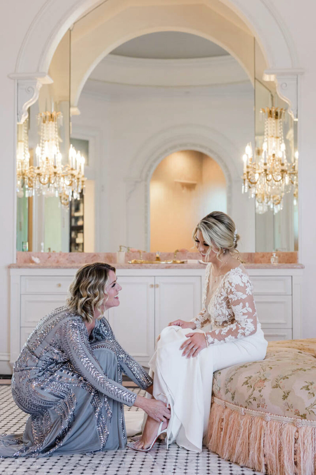 Mother putting Louboutin shoes on her daughter, the bride, at The Olana wedding venue, a European-style estate in Texas