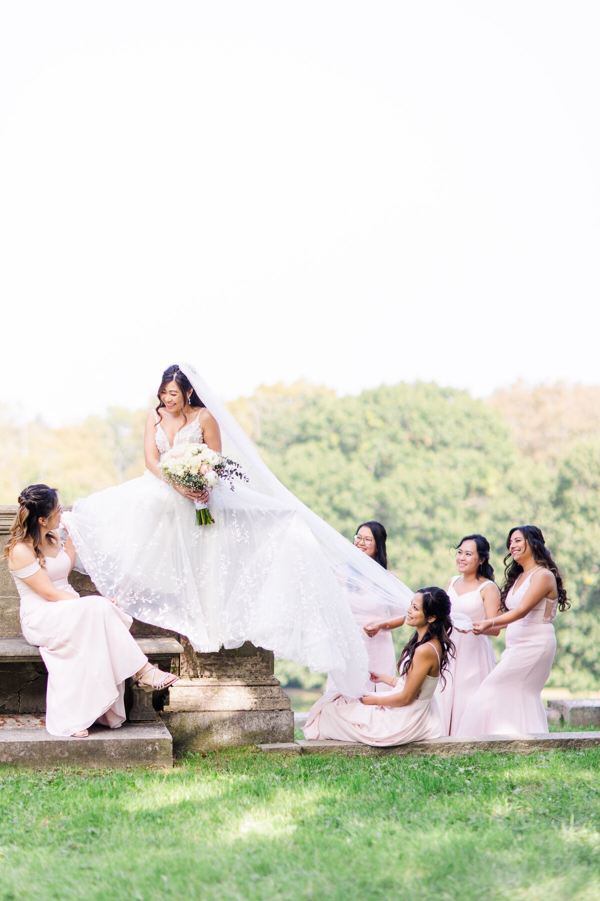 Bridesmaids fluffing the bride's dress during a Larz Anderson Park wedding