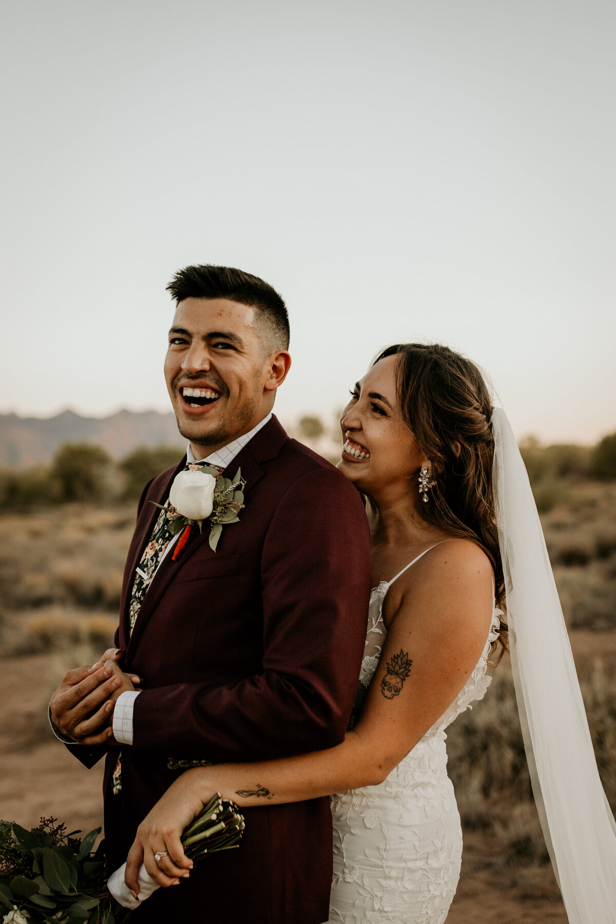 brida and groom laughing together in the Albuquerque desert
