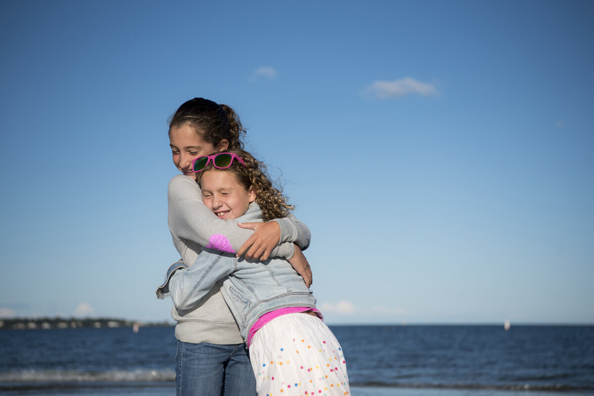 Two siblings hugging at the beach