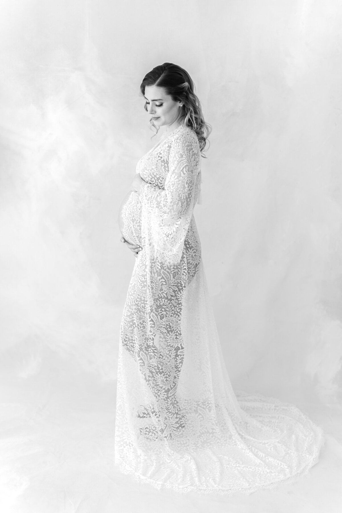 A Northern Virginia Maternity Photographer black and white photo of a pregnant mama in a lace boudoir gown