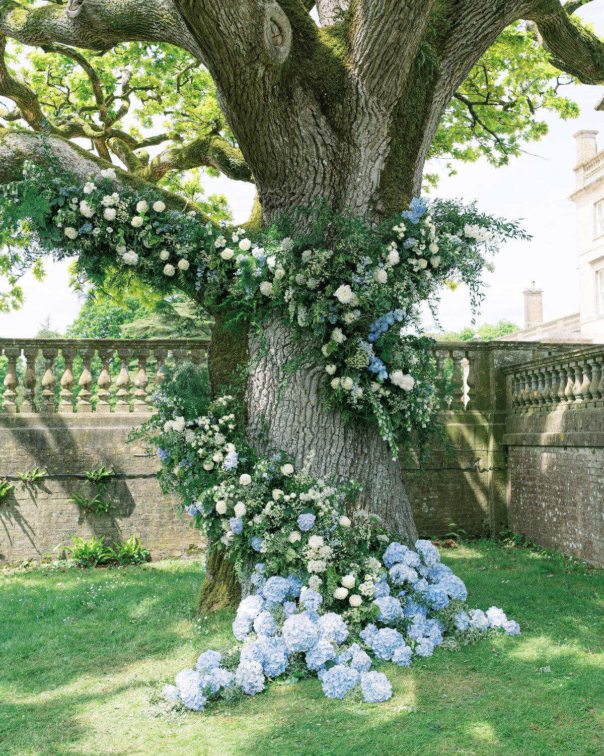 Outdoor wedding ceremony with blue and white floral installation