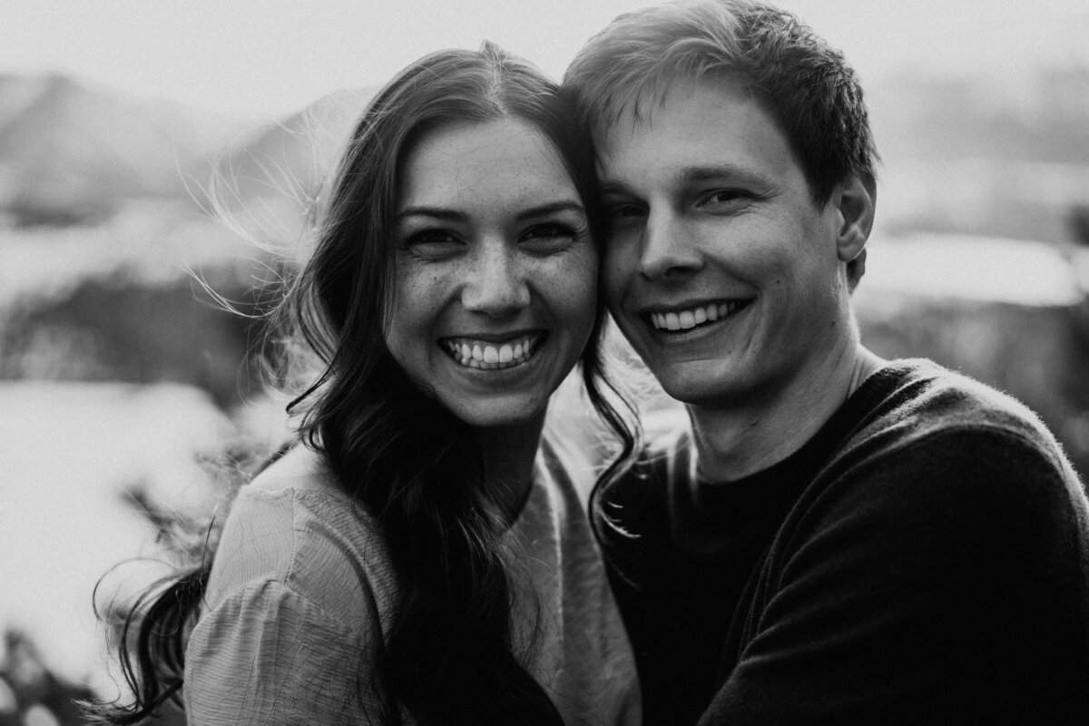 Smiling couple poses close together during Breckenridge engagement session at Sapphire Point.