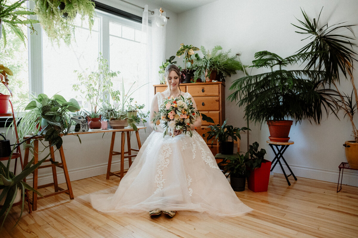 bride-sitting-in-the-middle-of-her-beautiful-living-room-filled-with-plants-in-quebec-city-1