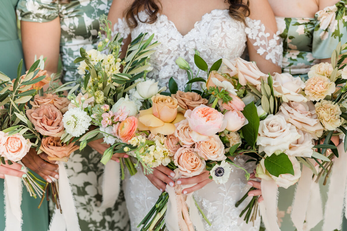 A close up view of a bride and groom's wedding rings. The rings are styled on an invitation along with wedding florals.