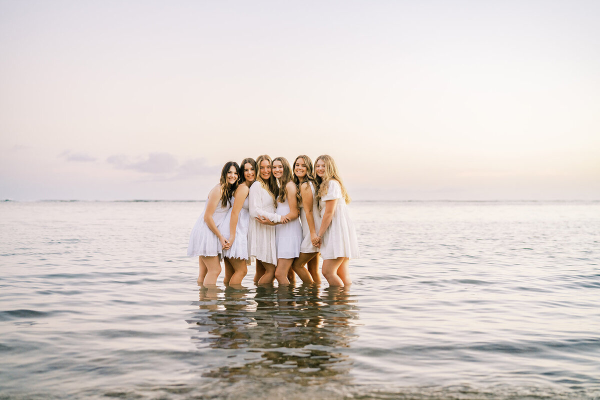 group of friends standing in the ocean for their senior portrait