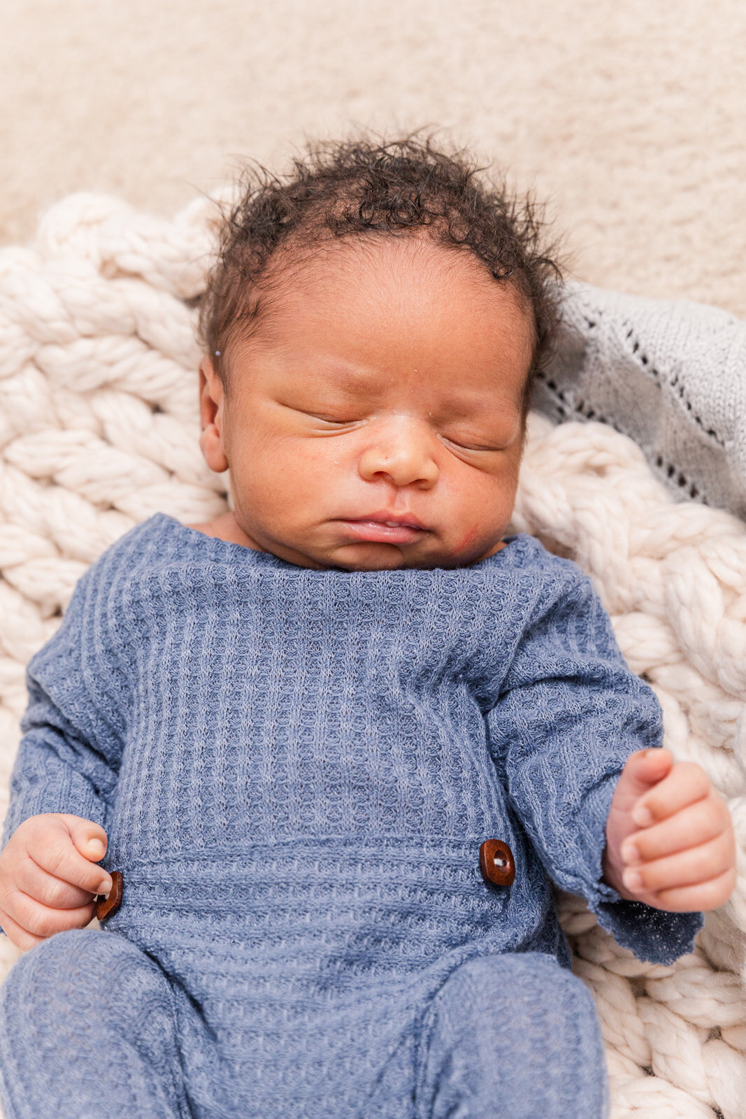 newborn baby boy wearing a blue outfit sleeping on a bed Laure Photography Atlanta family and newborn photographer