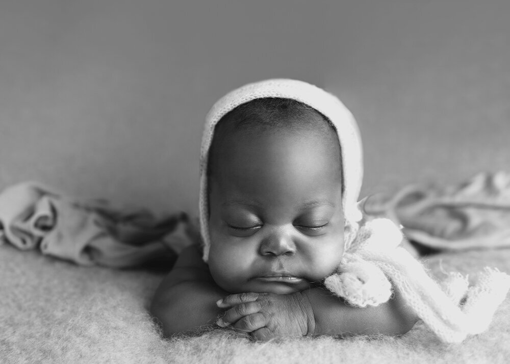 black-and-white-picture-of-newborn-girl-with-chin-on-hands