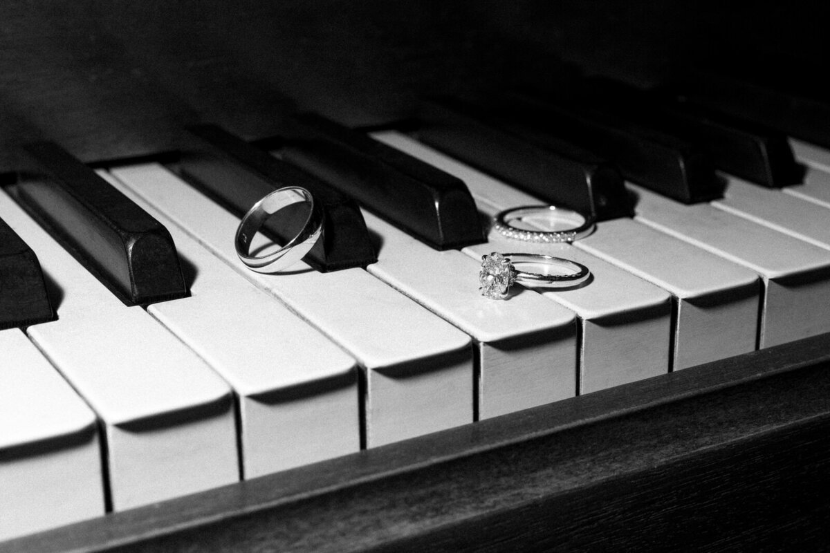 Wedding rings on a piano captured by Andrea-Marie Photography with off-camera flash