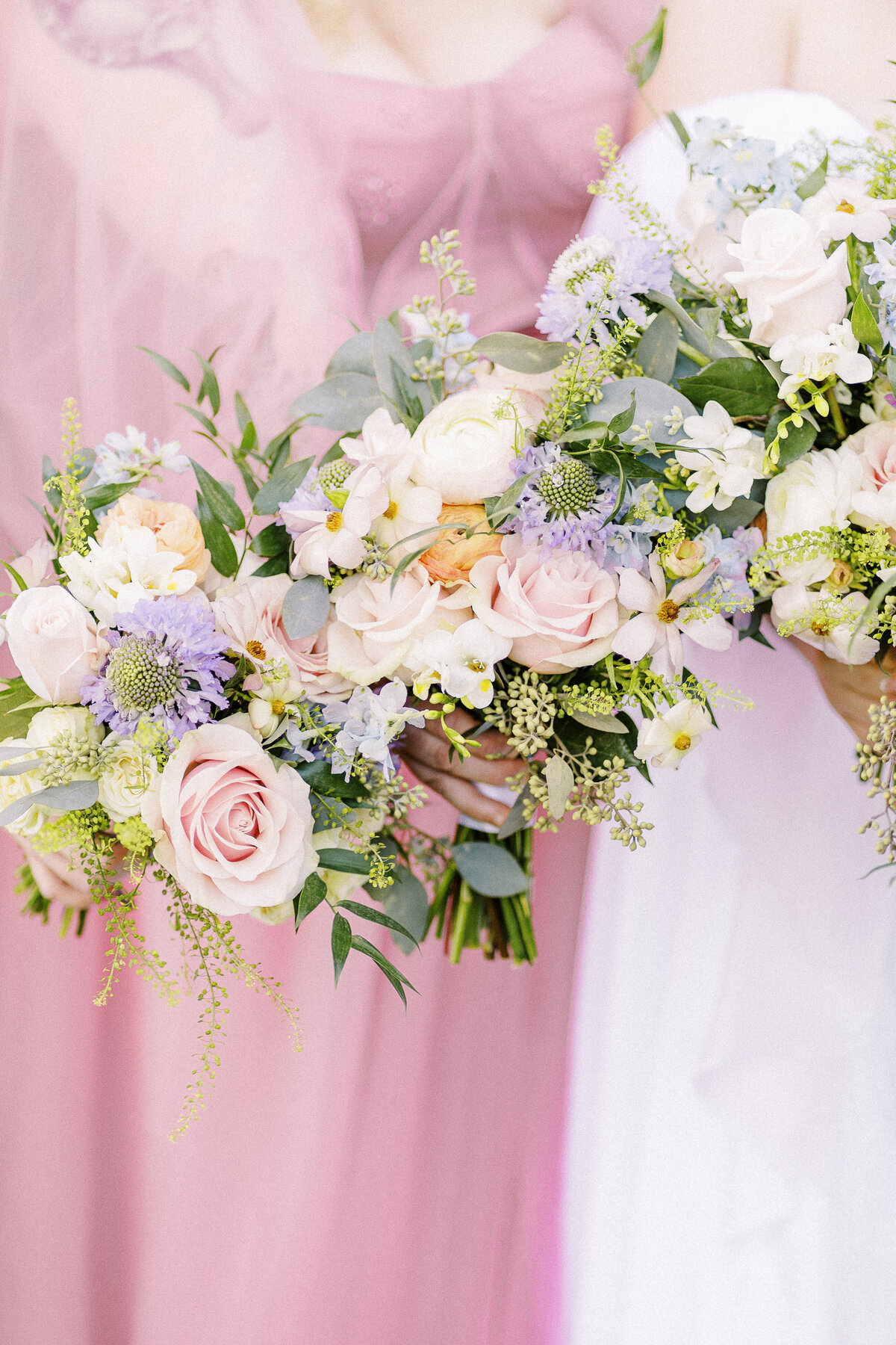 bridesmaids in blush pink dresses show off their spring color bouquets at a park winters wedding