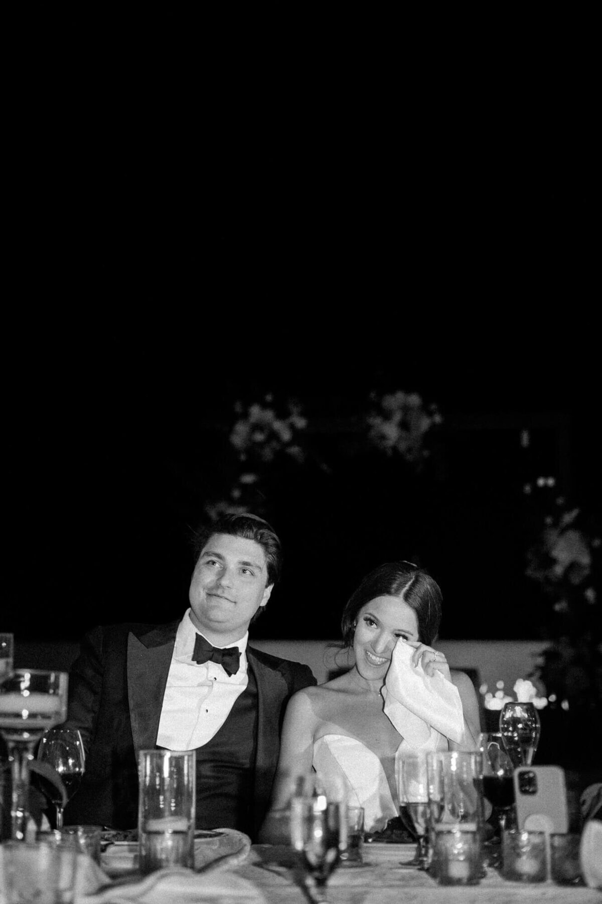 Bride wiping away tears during emotional wedding toasts beside her groom at Four Seasons Troon North, captured by Scottsdale wedding photographers.