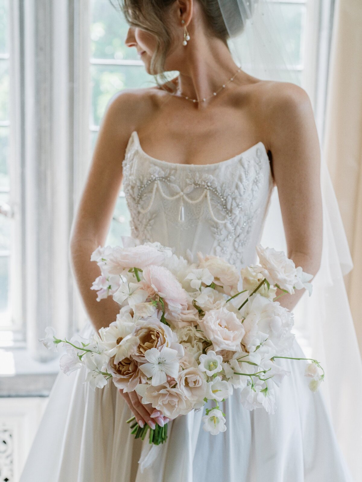 a bride in a wedding dress holding a flower bouquet