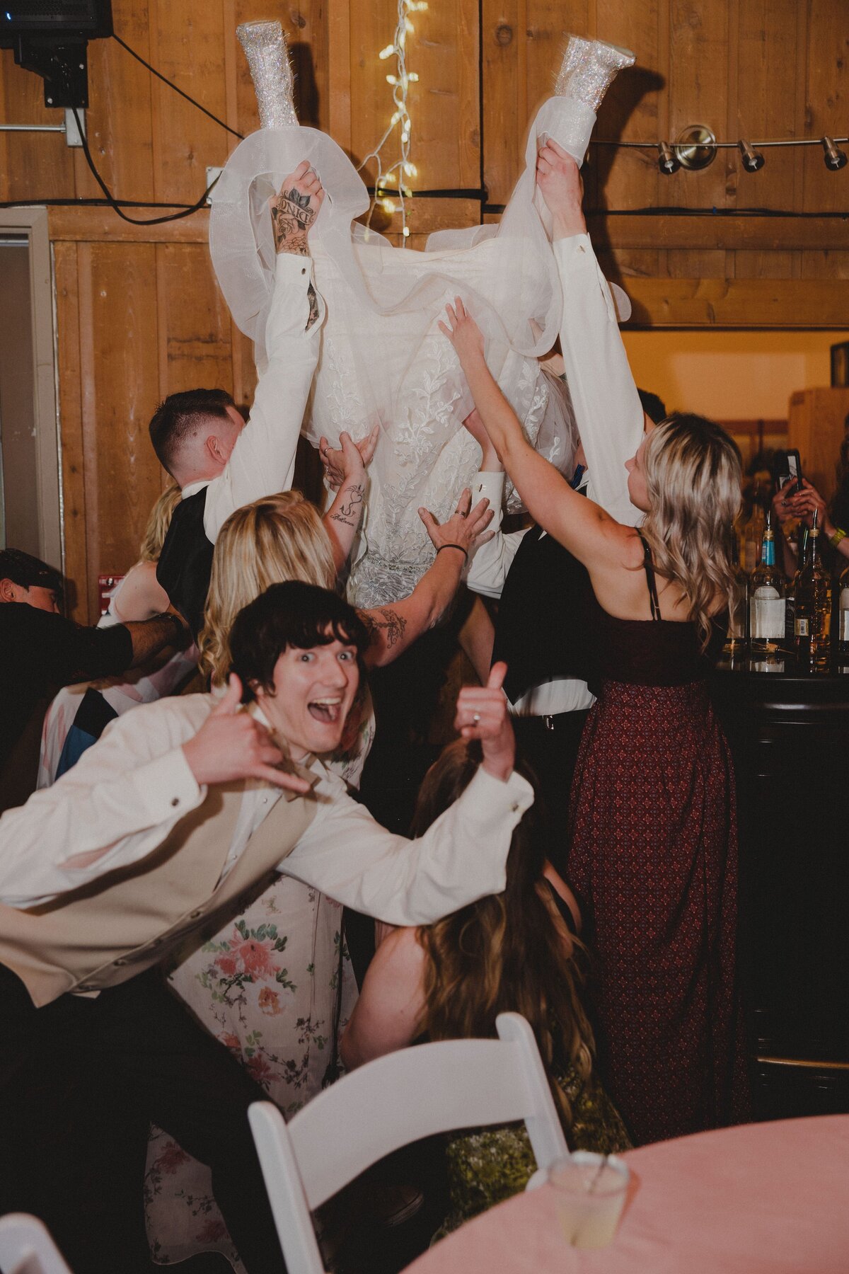 A bride does a keg stand during her wedding reception