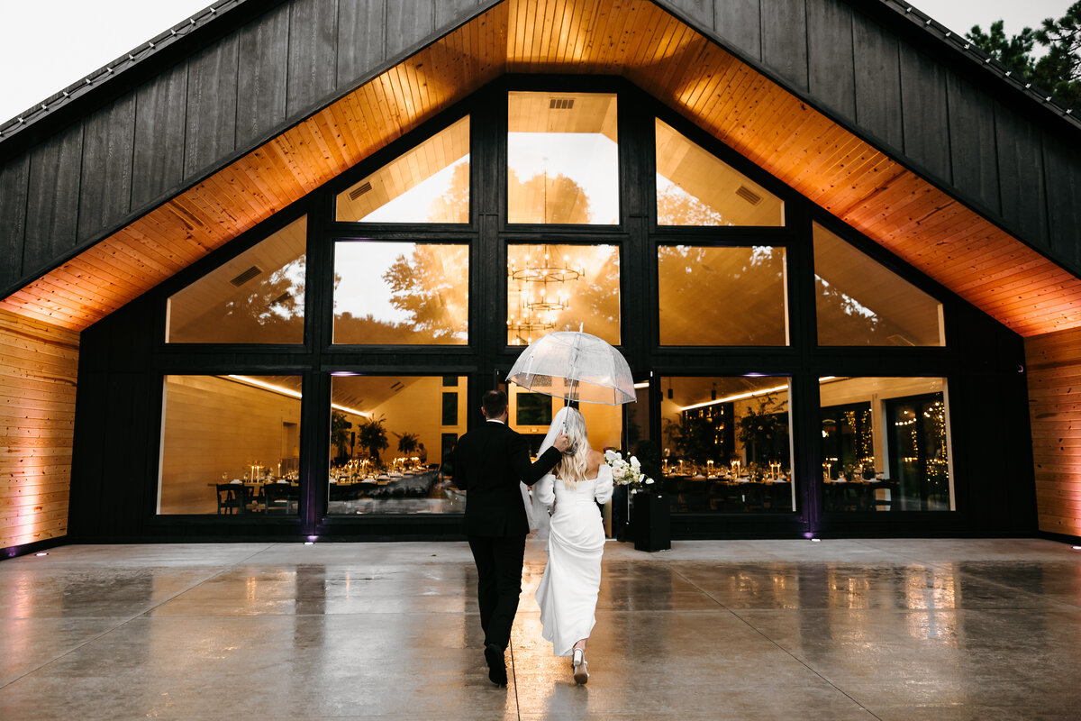 Bride and groom walking towards venue raising hands in the air