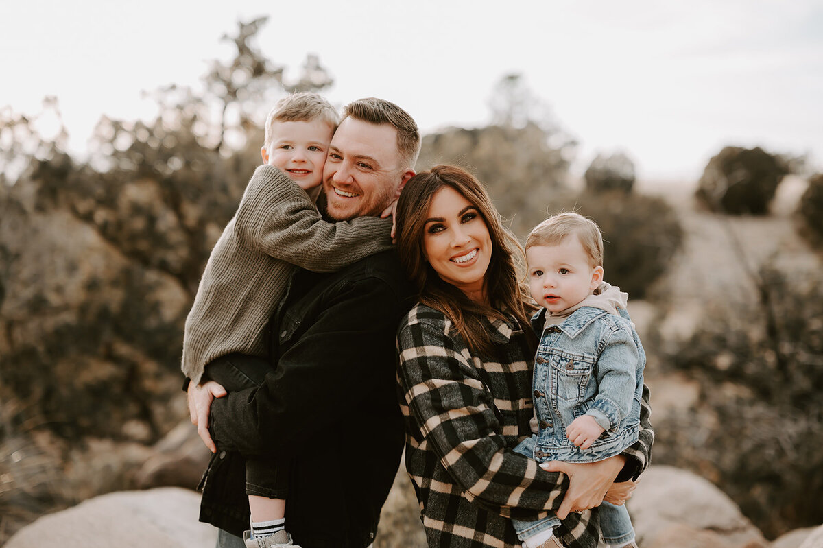 mom and dad holding boys in the foothills of New Mexico