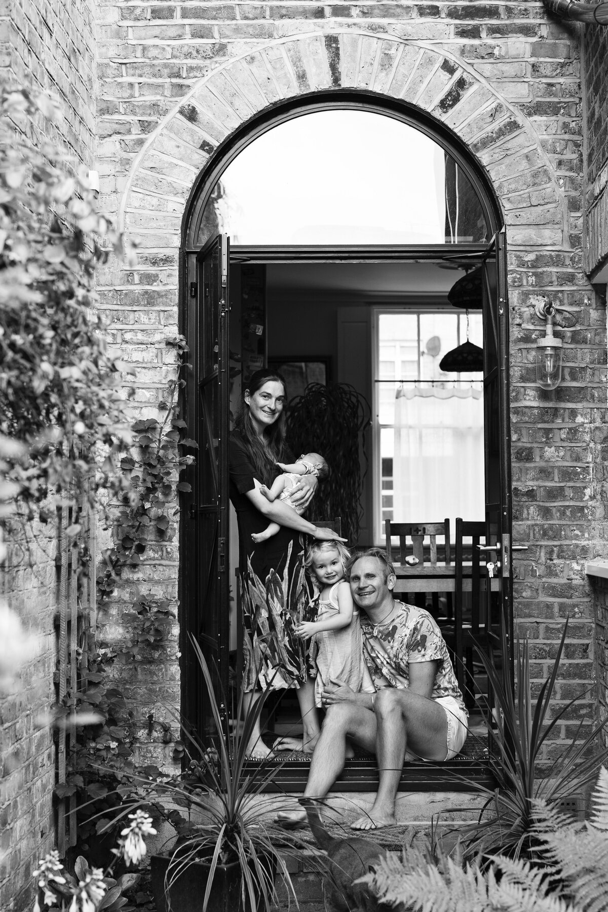 Family in the doorway of their home in east London during a relaxed photo shoot at home