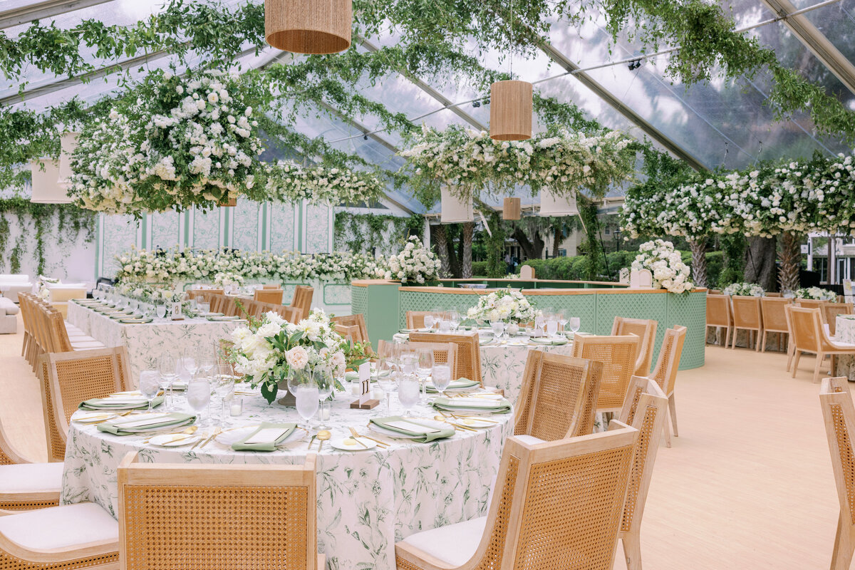 A clear tent with green and white florals decorating a reception space for a North Carolina Wedding