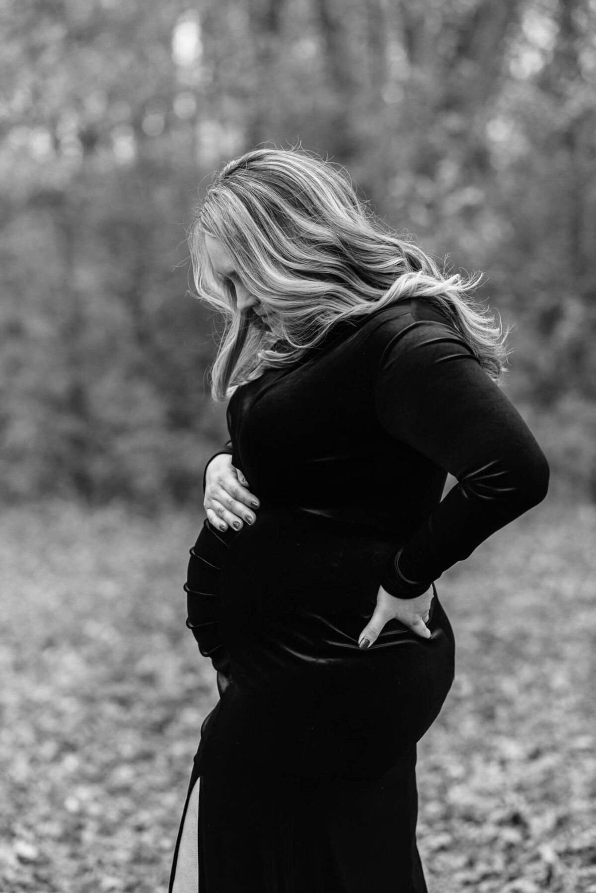 A beautiful mother in b&w looking at her bump, by a Northern Virginia maternity photographer, Denise Van