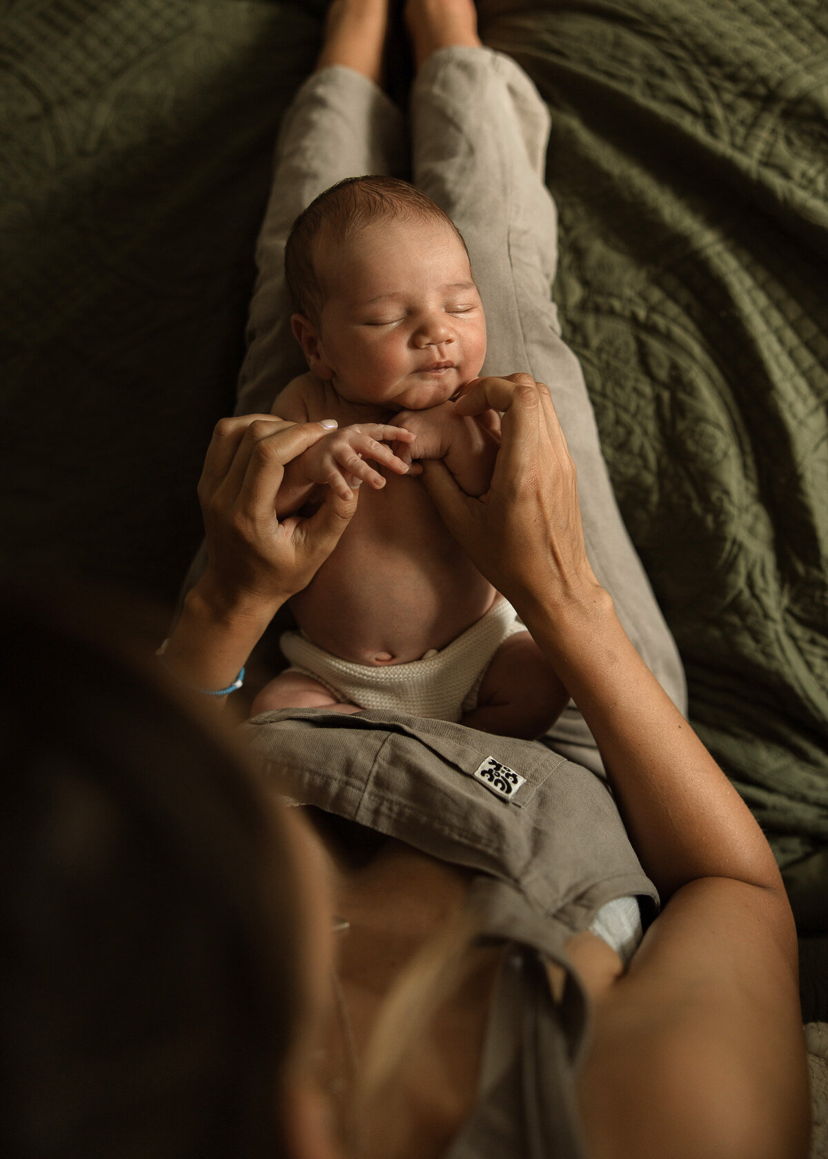 newborn baby on mother's legs