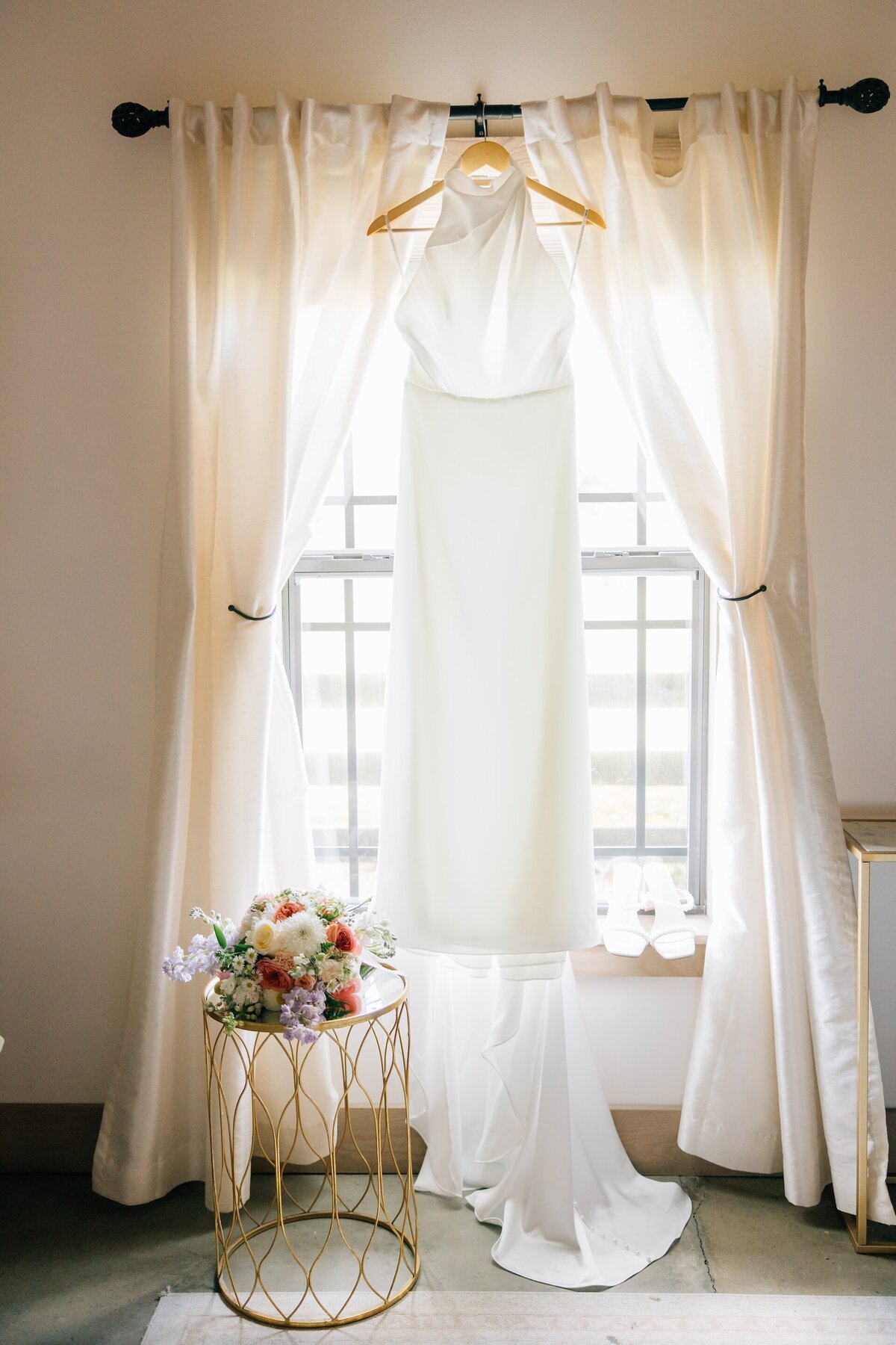 a wedding dress hanging up in a window