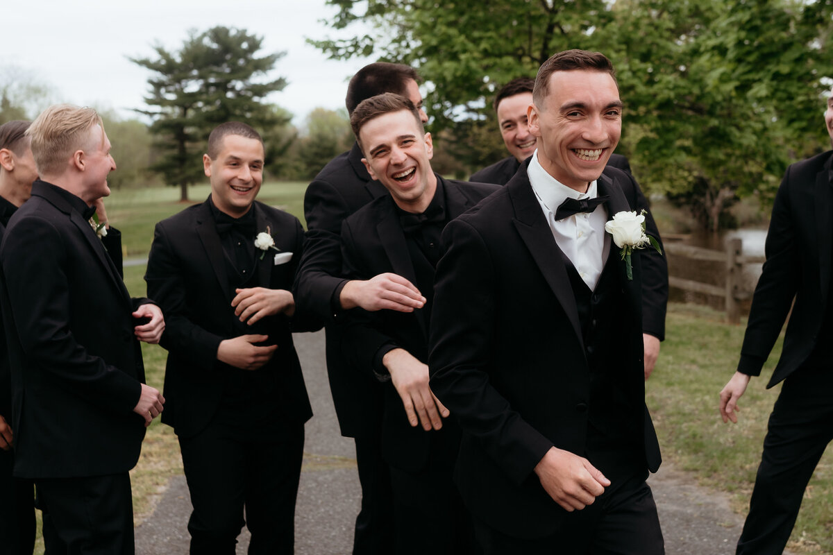 A candid moment of the groom and his groomsmen sharing laughter, captured in a natural, unscripted style. This genuine interaction showcases the documentary wedding photography approach, highlighting authentic emotions during a Pennsylvania wedding