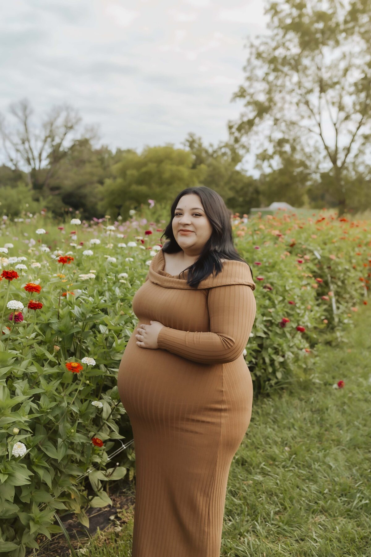 Maternity session among flowers at flower farm in Missouri with a warm and bright feel