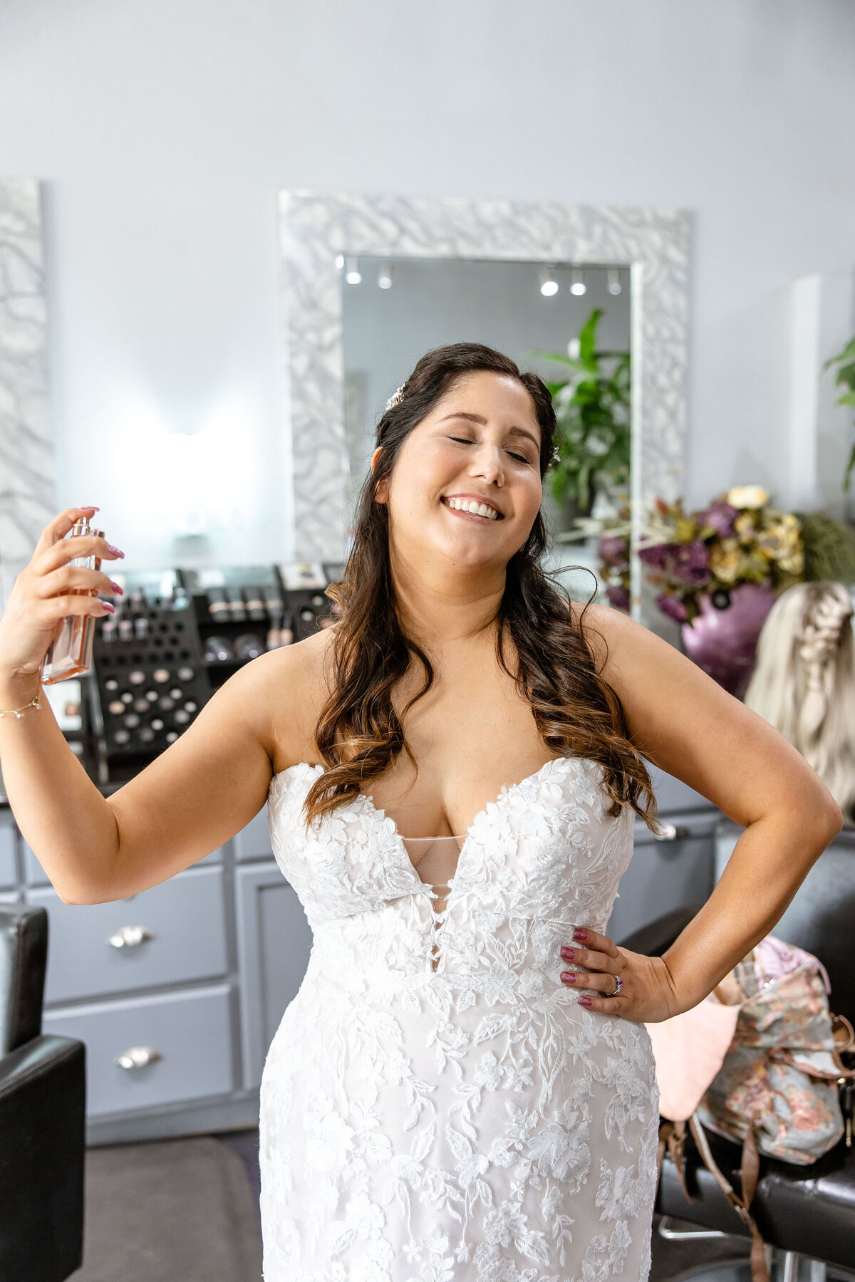 bride sprays perfume in salon before wedding in San Antonio Texas