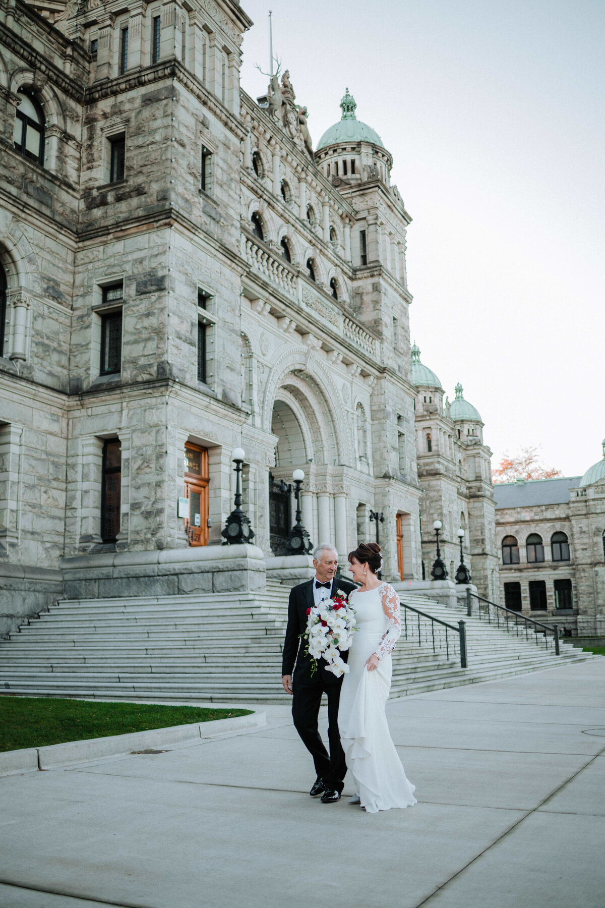 Mature couple walking hand-in-hand after city wedding ceremony