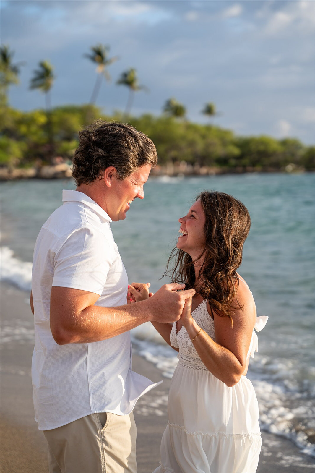 Couple holding hands and laughing for Hawaii engagement photos
