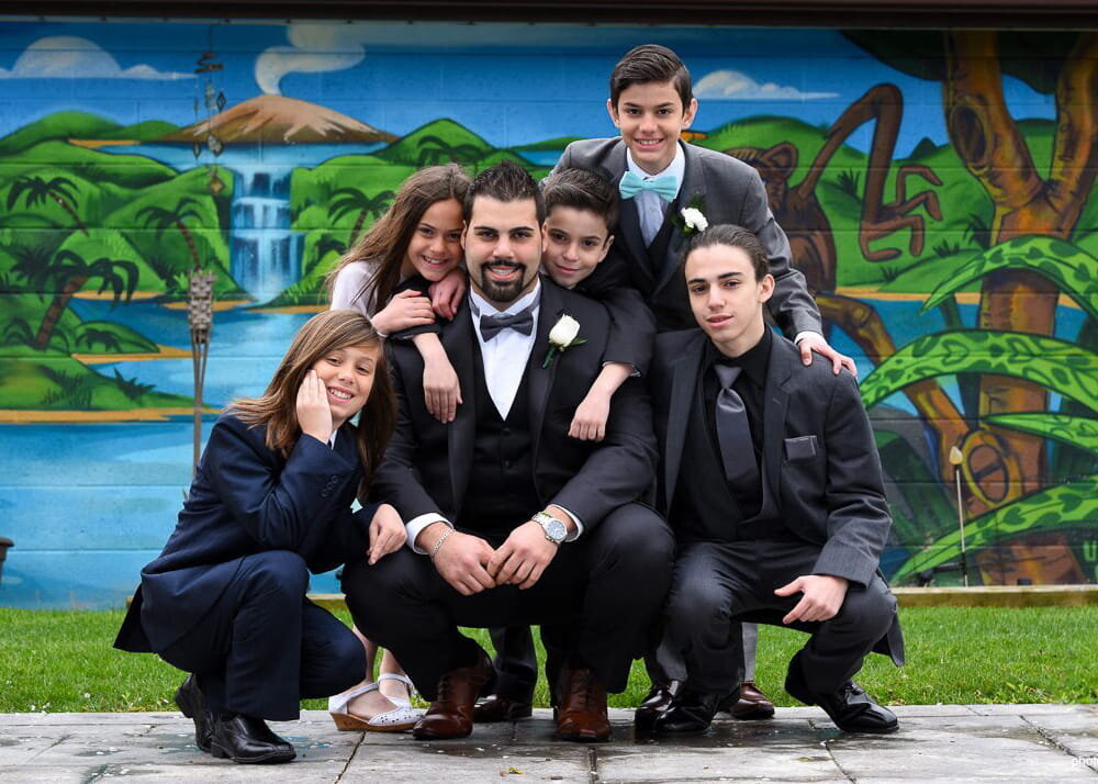 Groom with Children at Wedding with Tropical Mural