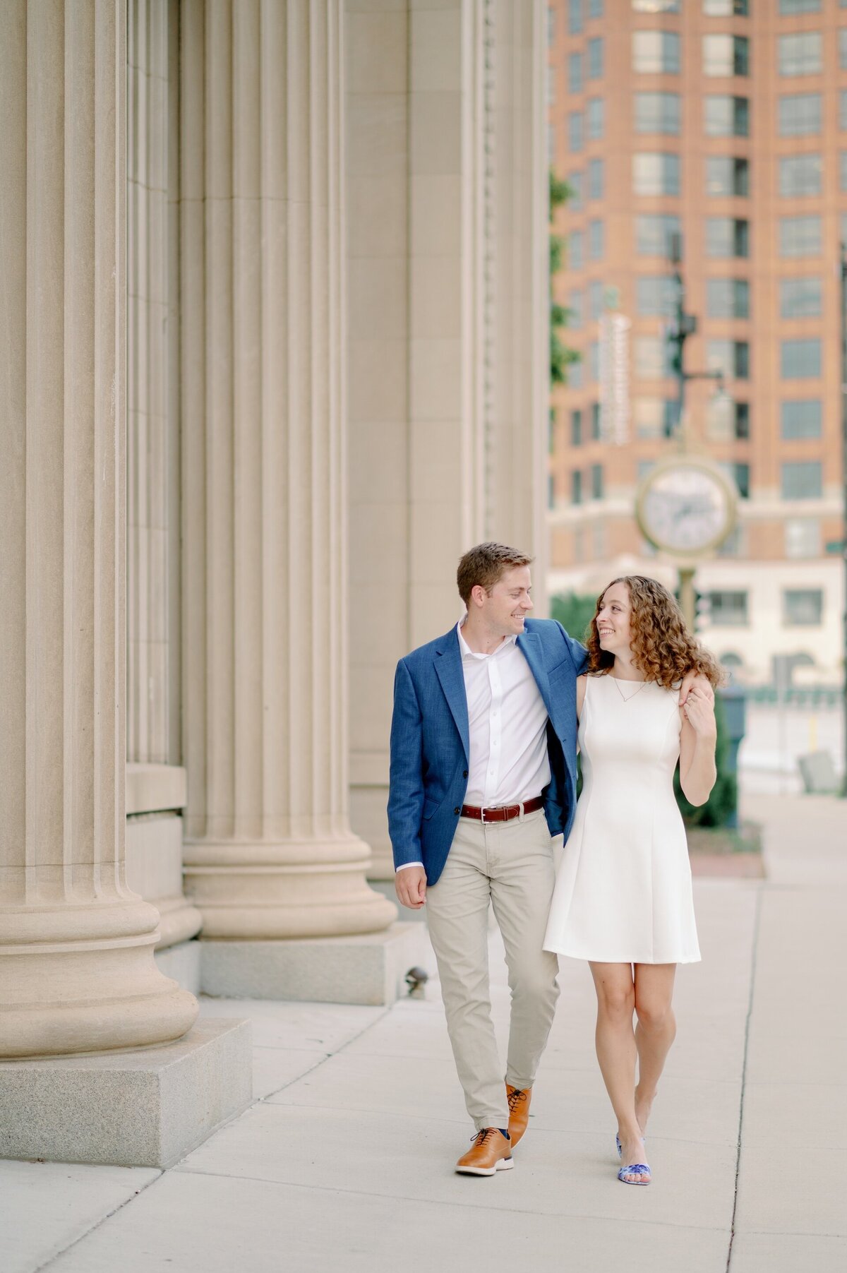 engaged couple kissing on the sidewalk in Milwaukee Historic Society