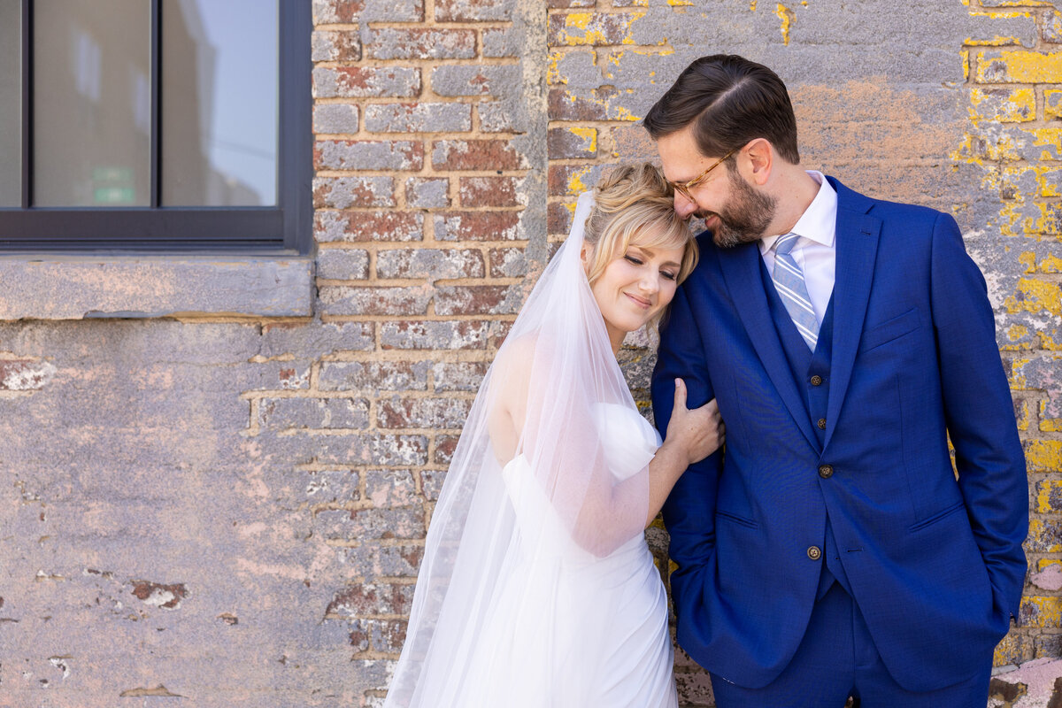 Bride and Groom embrace one another outside of an industrial building. Wedding reception in Ohio. Photographed by Aaron Aldhizer