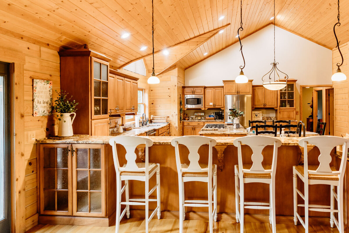 Spacious kitchen with a wooden ceiling and breakfast bar seating