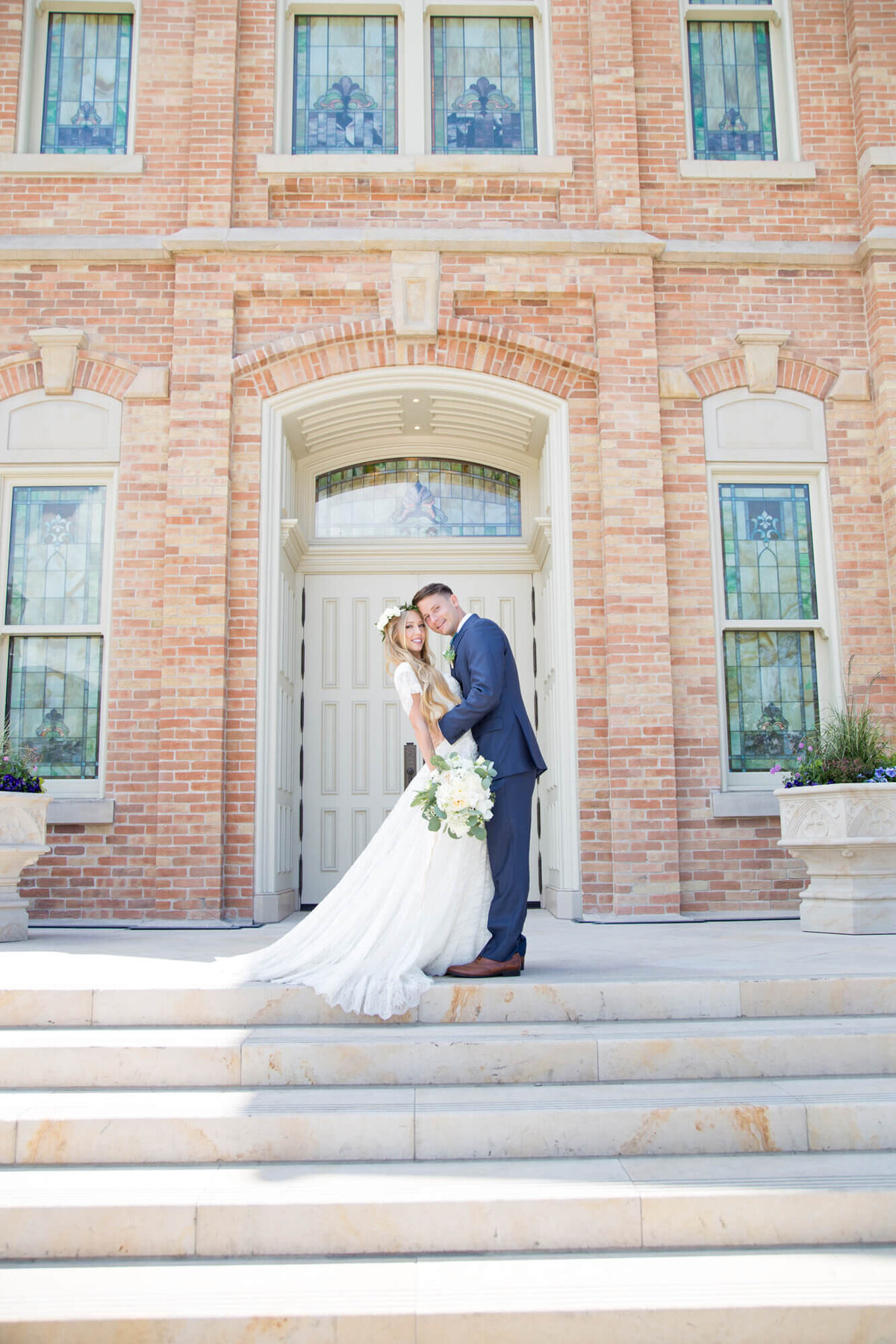 a wedding couple posing at the top of stairs