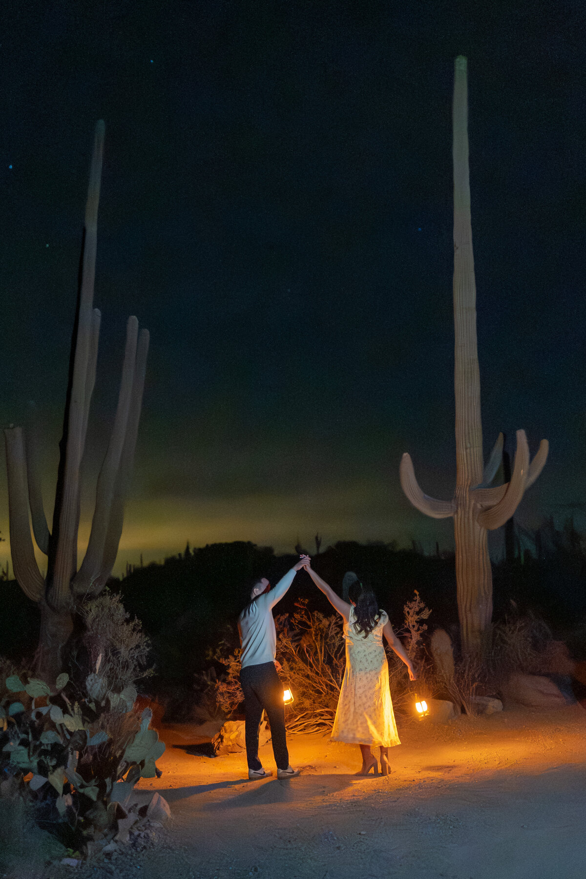 Tucson Saguaro Arizona Elopement with Bride Groom during Vibrant Sunset Blue Hour at Night holding lanterns among tall cacti.