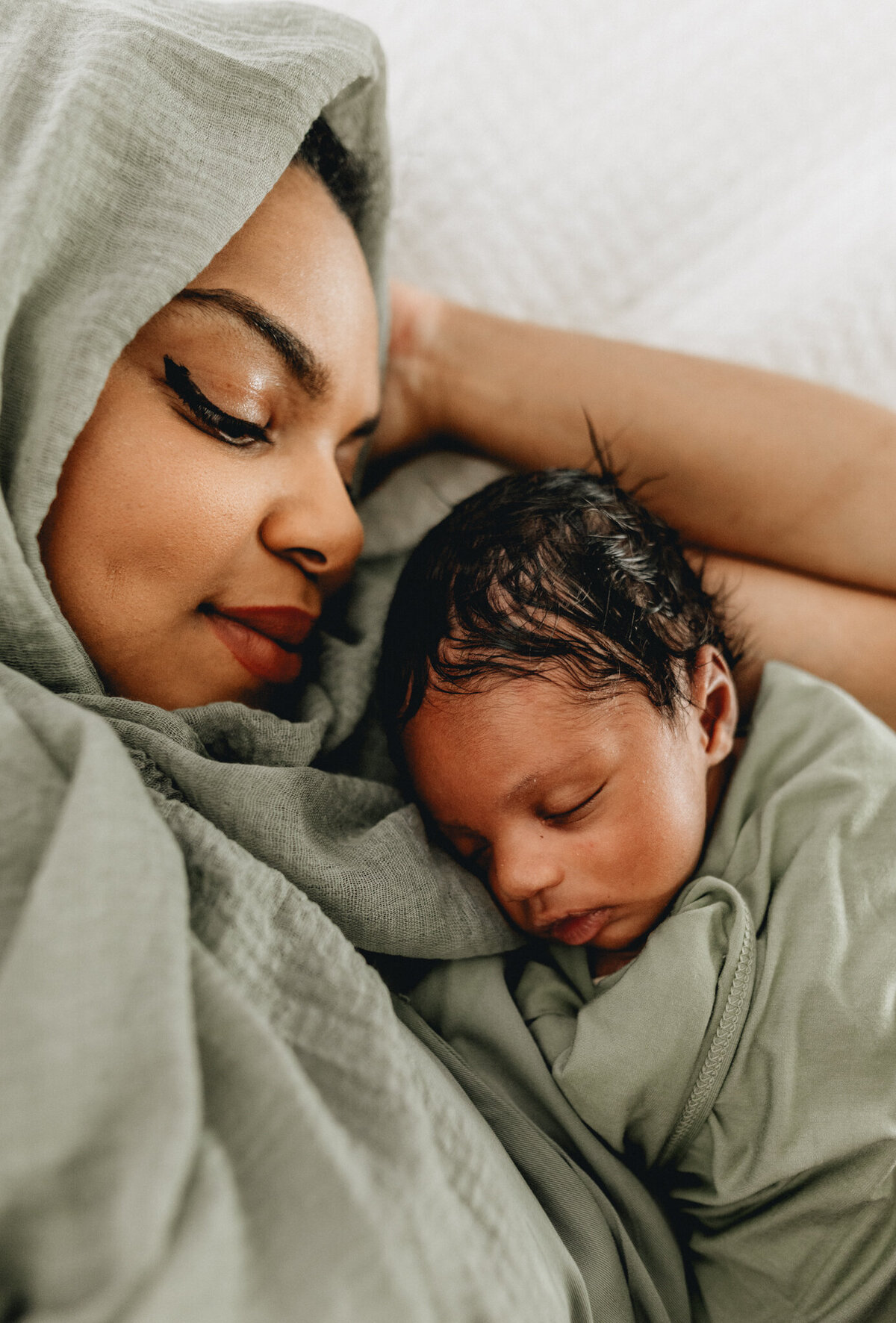 Newborn photography of mother holding newborn babe.
