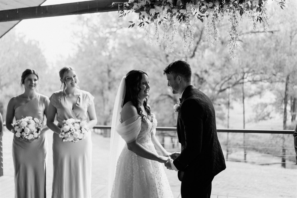 A couple shares laughter and holds hands during their ceremony, radiating joy and love.