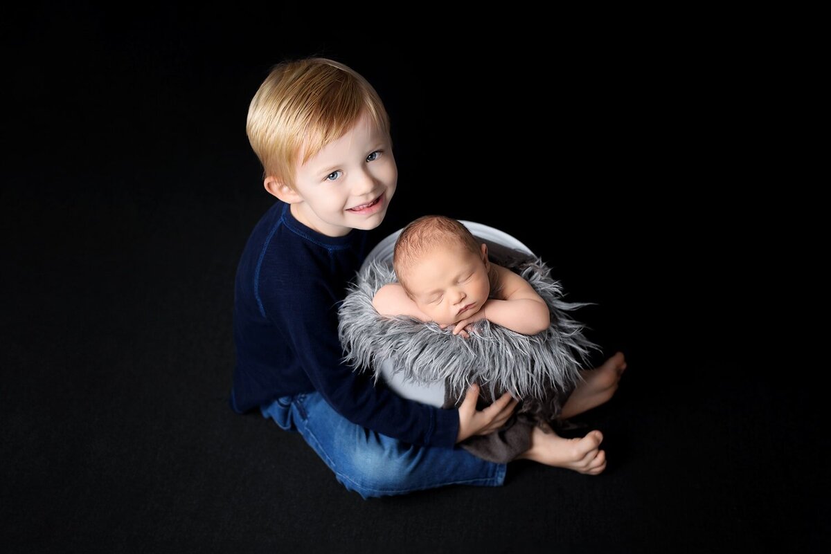 Newborn sibling photoshoot in New Westminster with toddler brother and baby boy in bucket