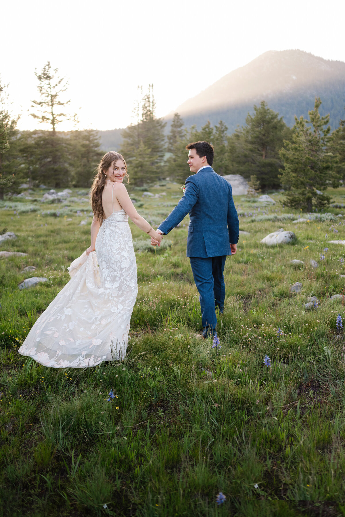 Couple walks in meadow after destination wedding