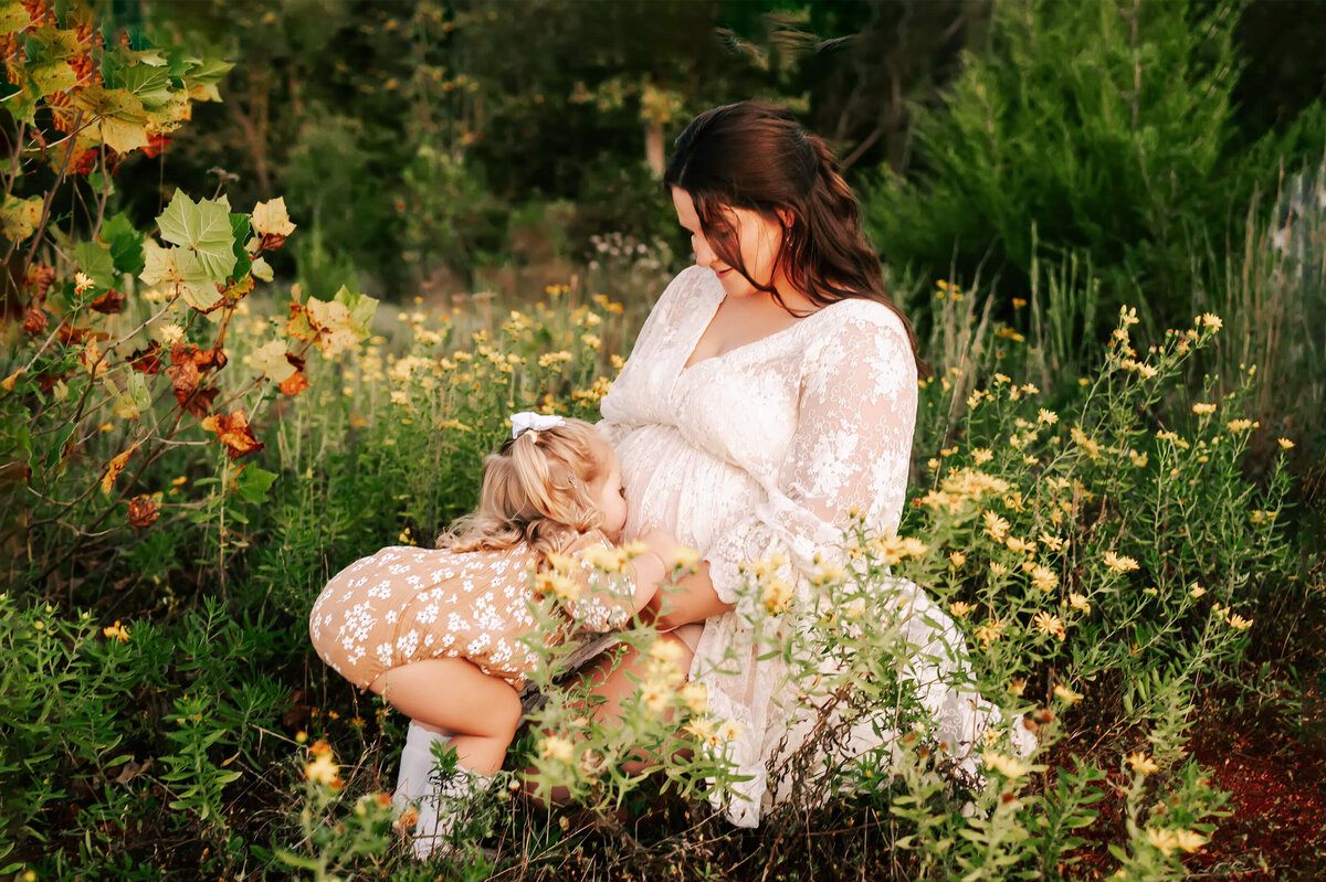 toddler kissing pregnant mom's baby bump captured by Branson Mo maternity photographer Jessica Kennedy of The XO Photography