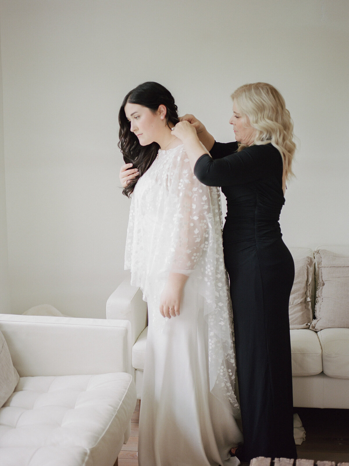 Bride with bridal cape prepares in white getting ready space, Michigan wedding venue
