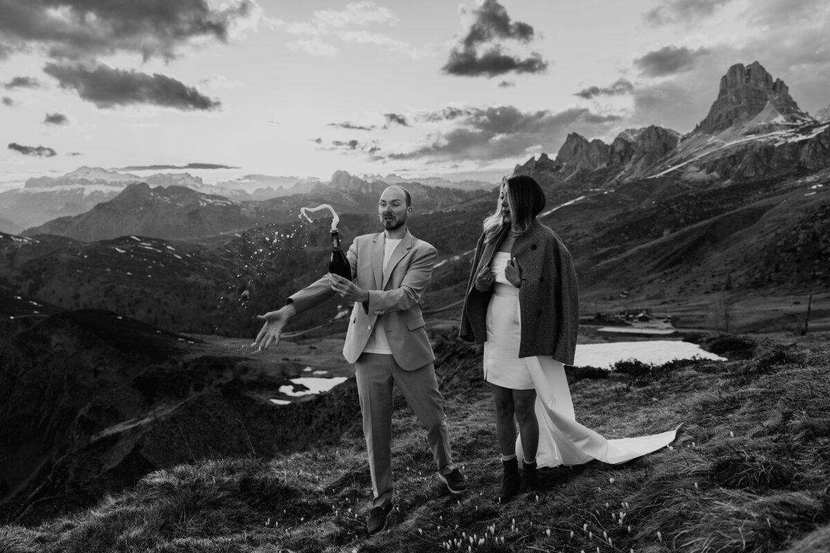 romantic couple drinking wine during twilight elopement in Dolomites