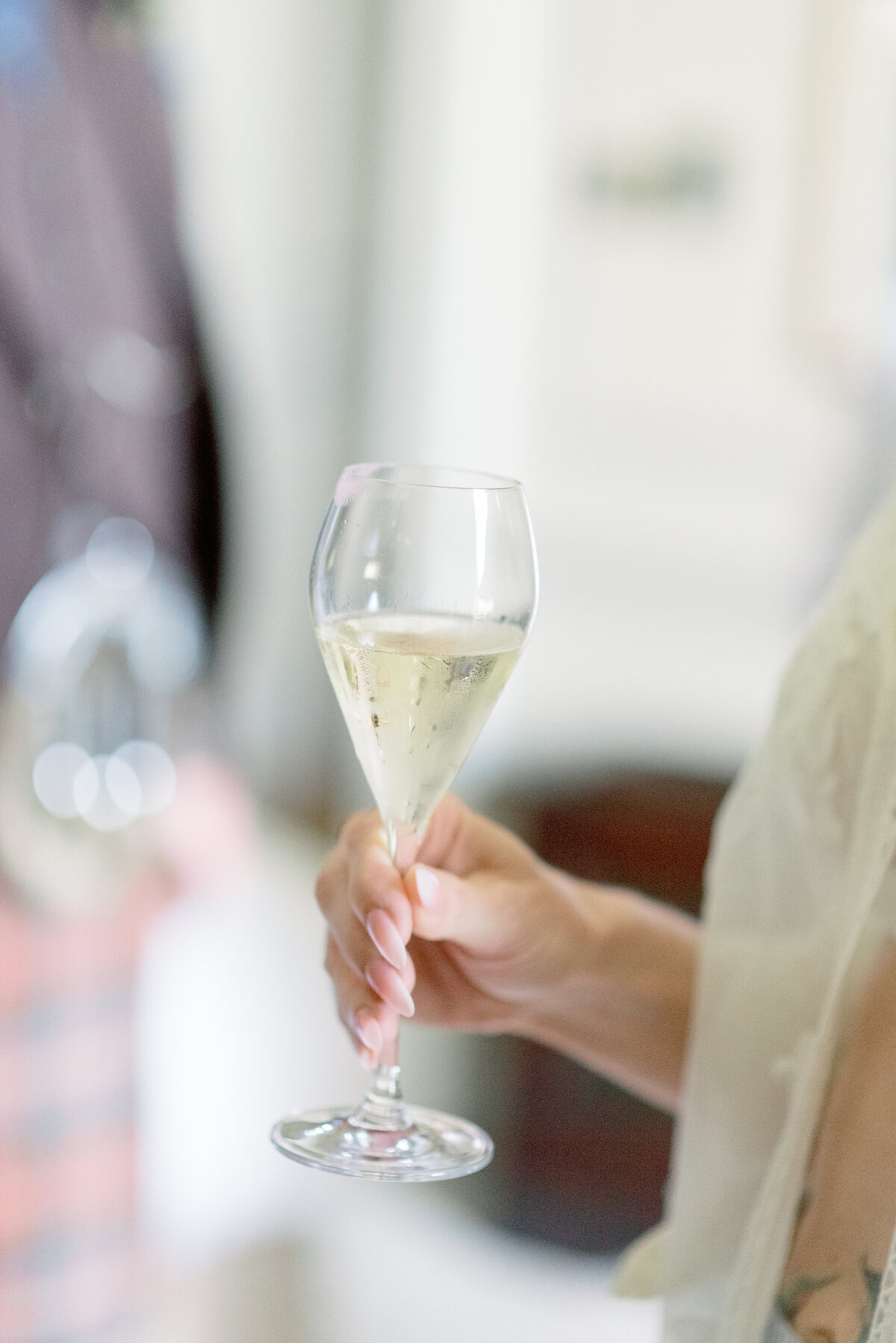 Champagne glass in the hand of a Bride on the morning of her Gleneagles wedding day.  Image by luxury fine art wedding photographer, Scotland, Jill Cherry Porter.