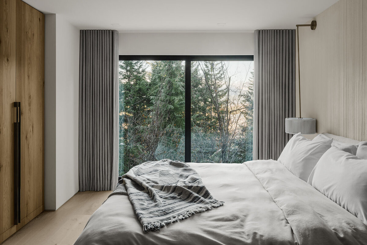 Master bedroom at modern cabin with custom wood cabinetry designed by Los Angeles architect.