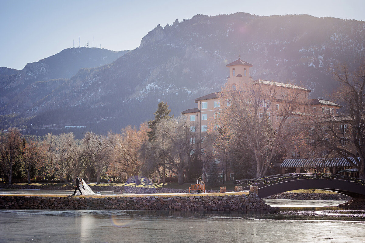 Bride and Groom cross the bridge of the lake at the Broadmoor Hotel.