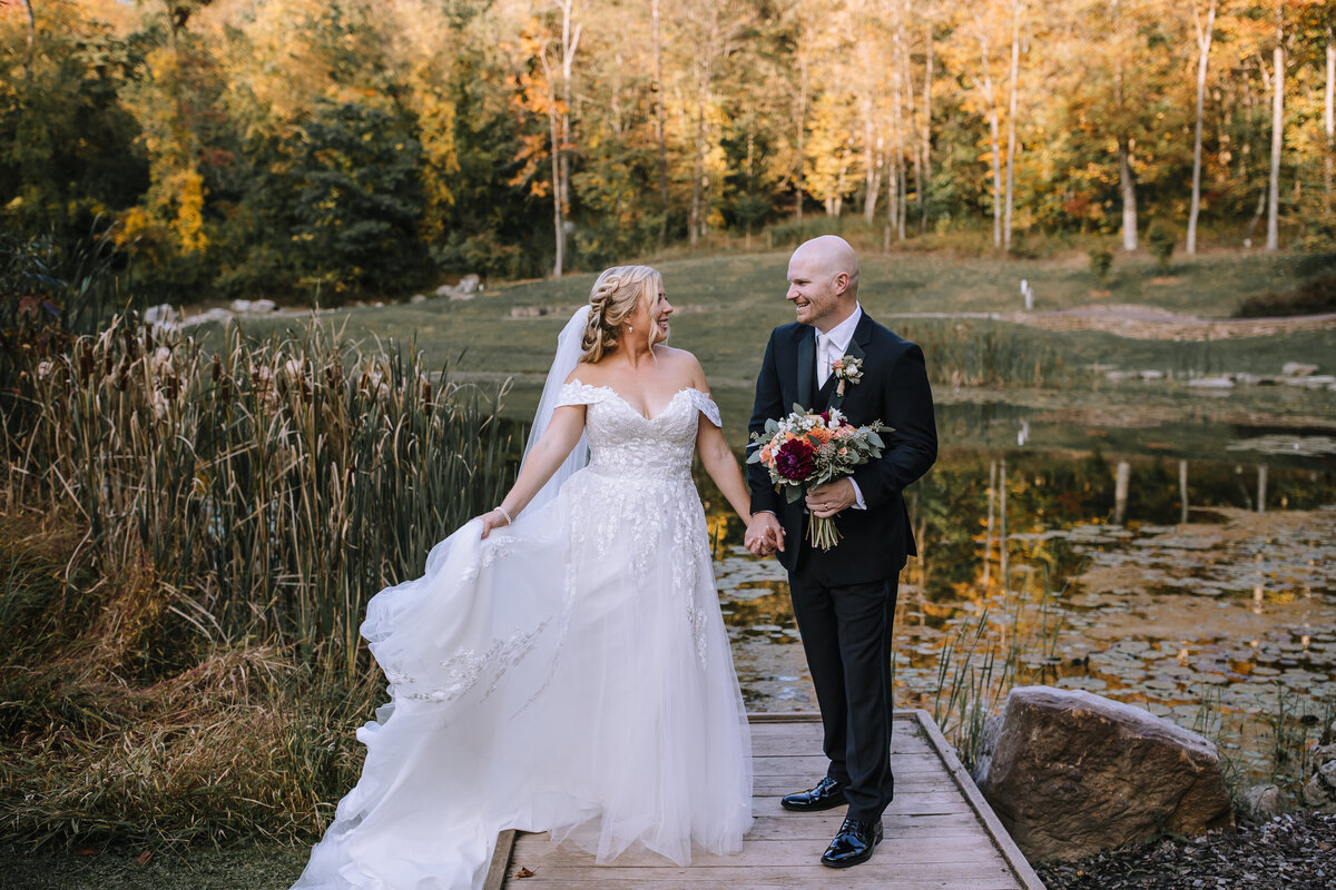 Bride and groom on a dock at the Pittsburgh Botanic Gardens.