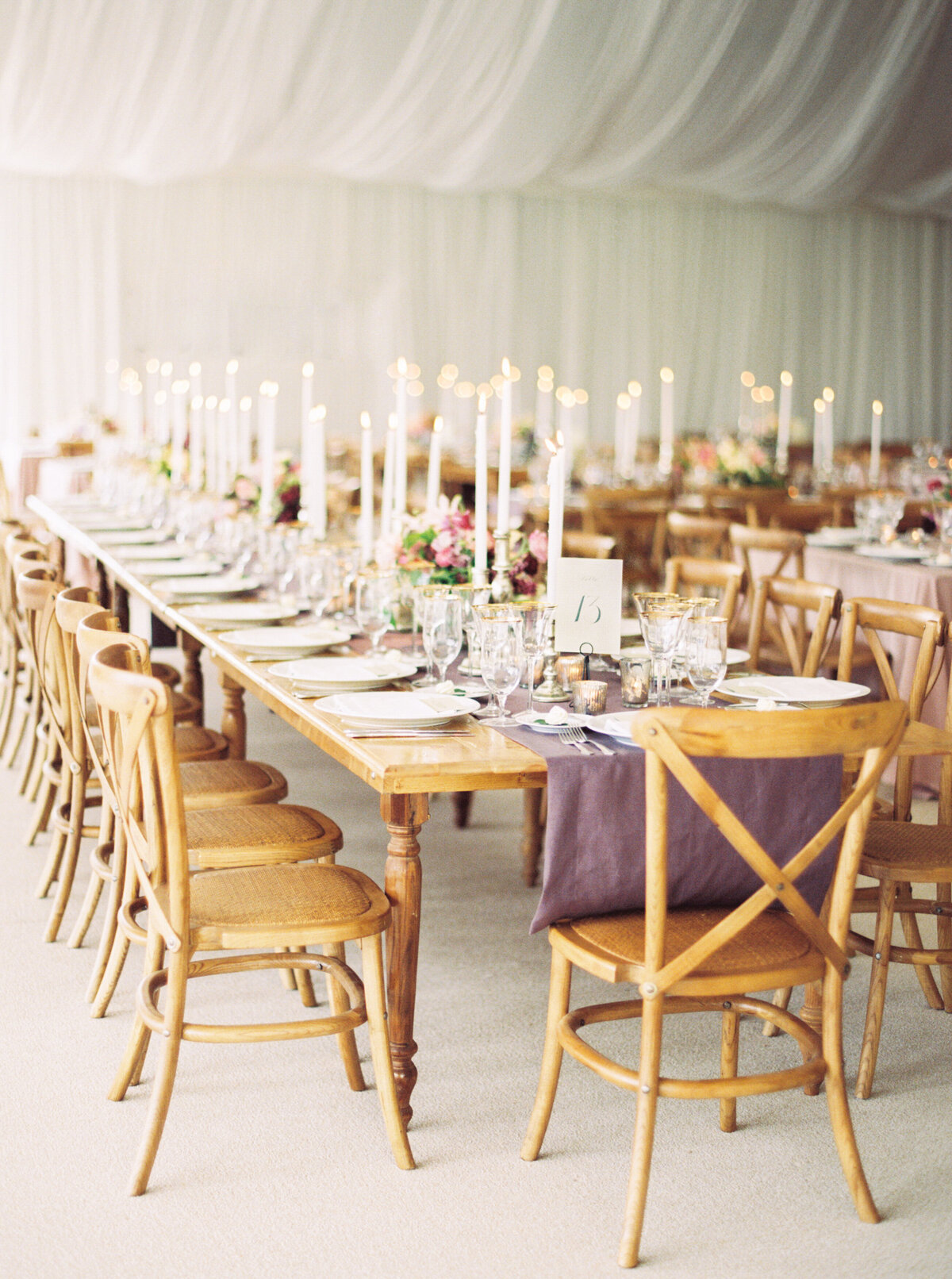 tented-outdoor-wedding-long-wooden-table-purple-runner-candlesticks