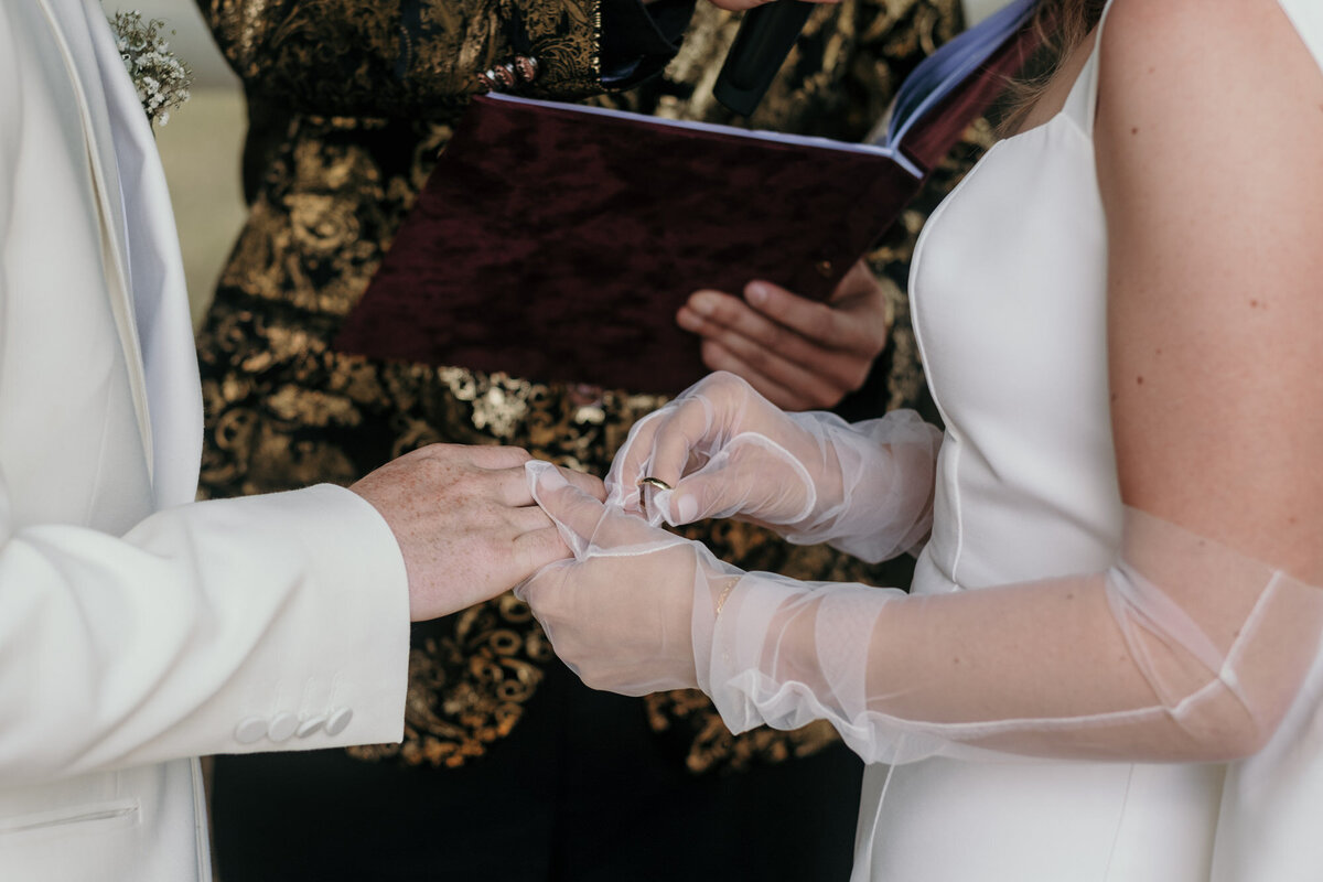 Die Braut hat den Ehering in der Hand, um ihn ihrem Bräutigam anzustecken.