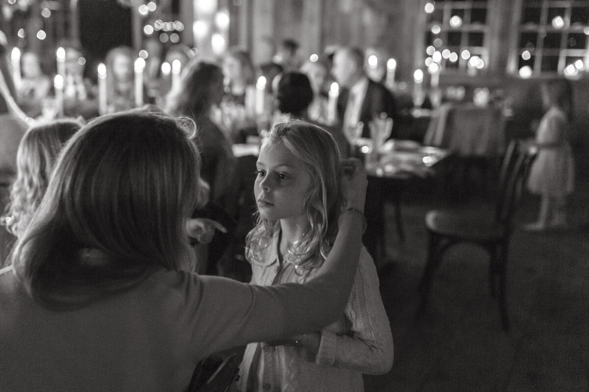 Mom brushing hair out of daughters face during dinner at The Castaway in Portand.
