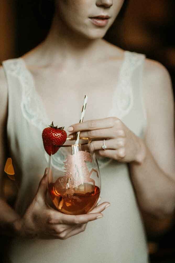 Bride-closeup-holding-glass-with-straw-and-strawberry-ring-closeup-Missouri-wedding-photographer